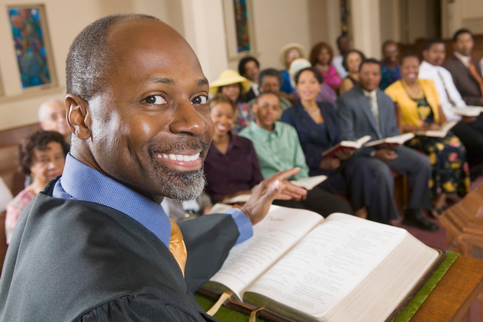 Smiling preacher at the pulpit in front of his congregation 